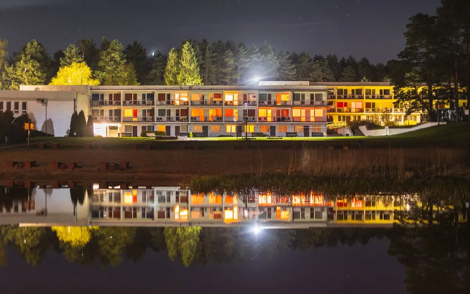 Beautiful night view of a lakeside holiday resort with lights reflecting on the water.